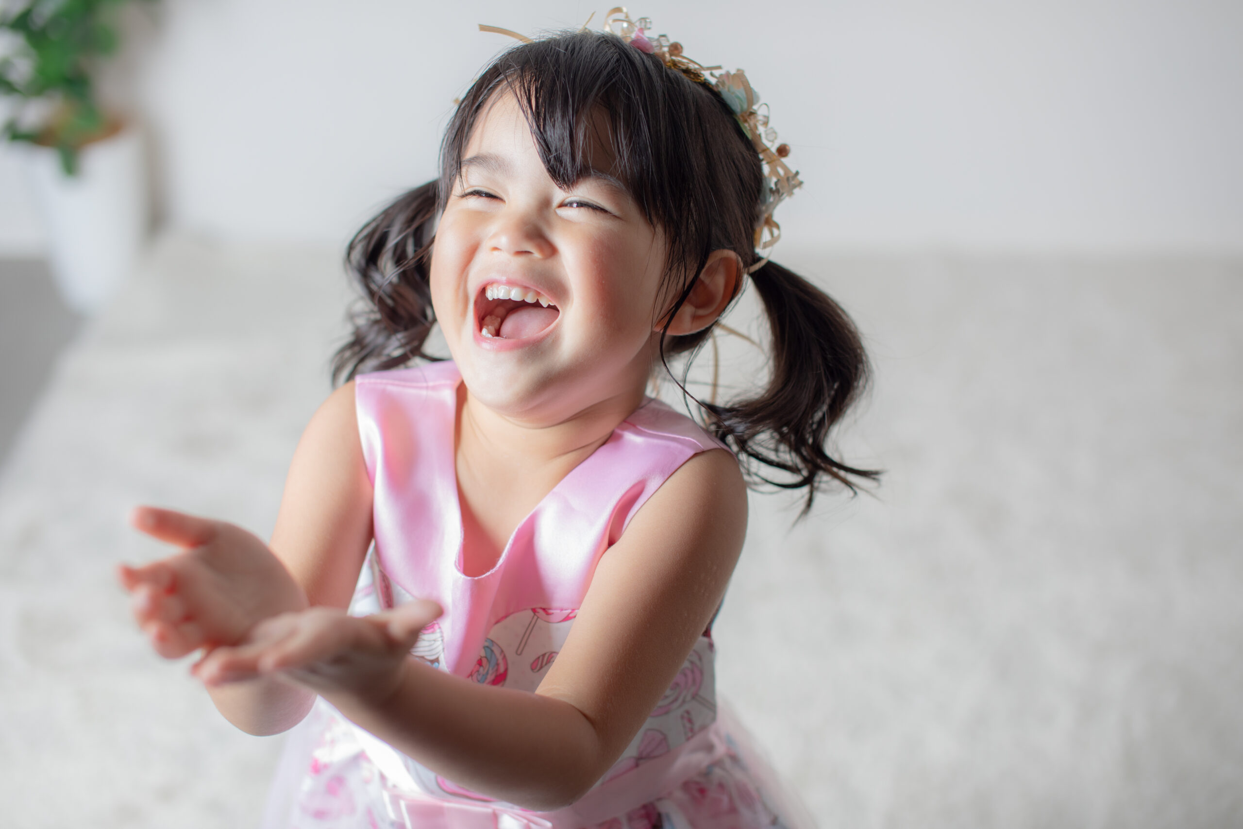 ピンクのドレスを着て笑う３歳の女の子