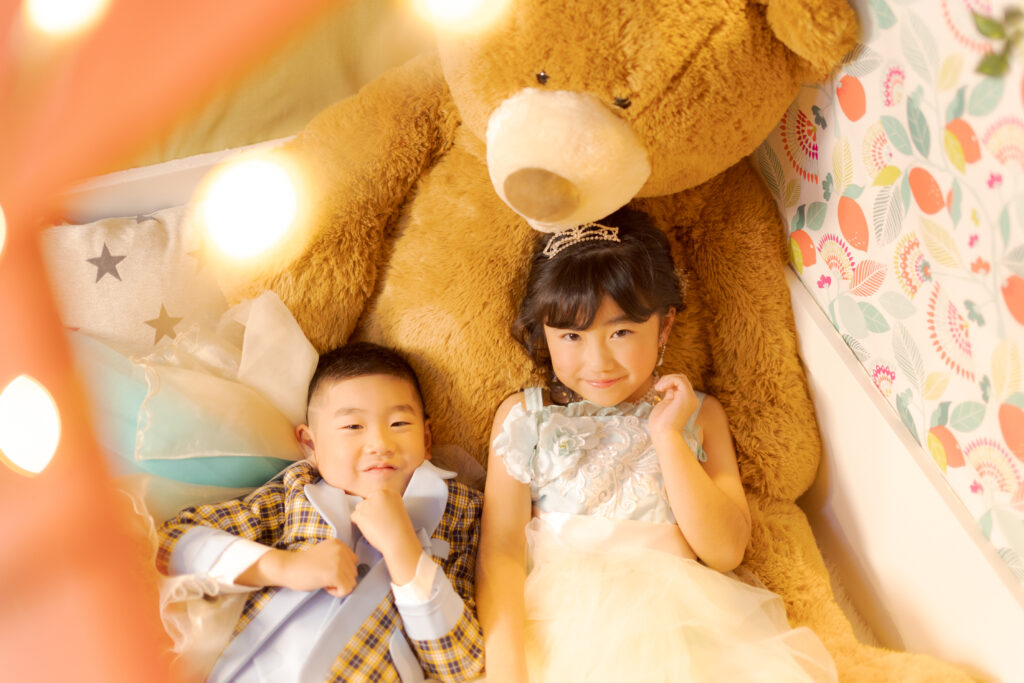 お気に入りのぬいぐるみと一緒に七五三の撮影をする子ども