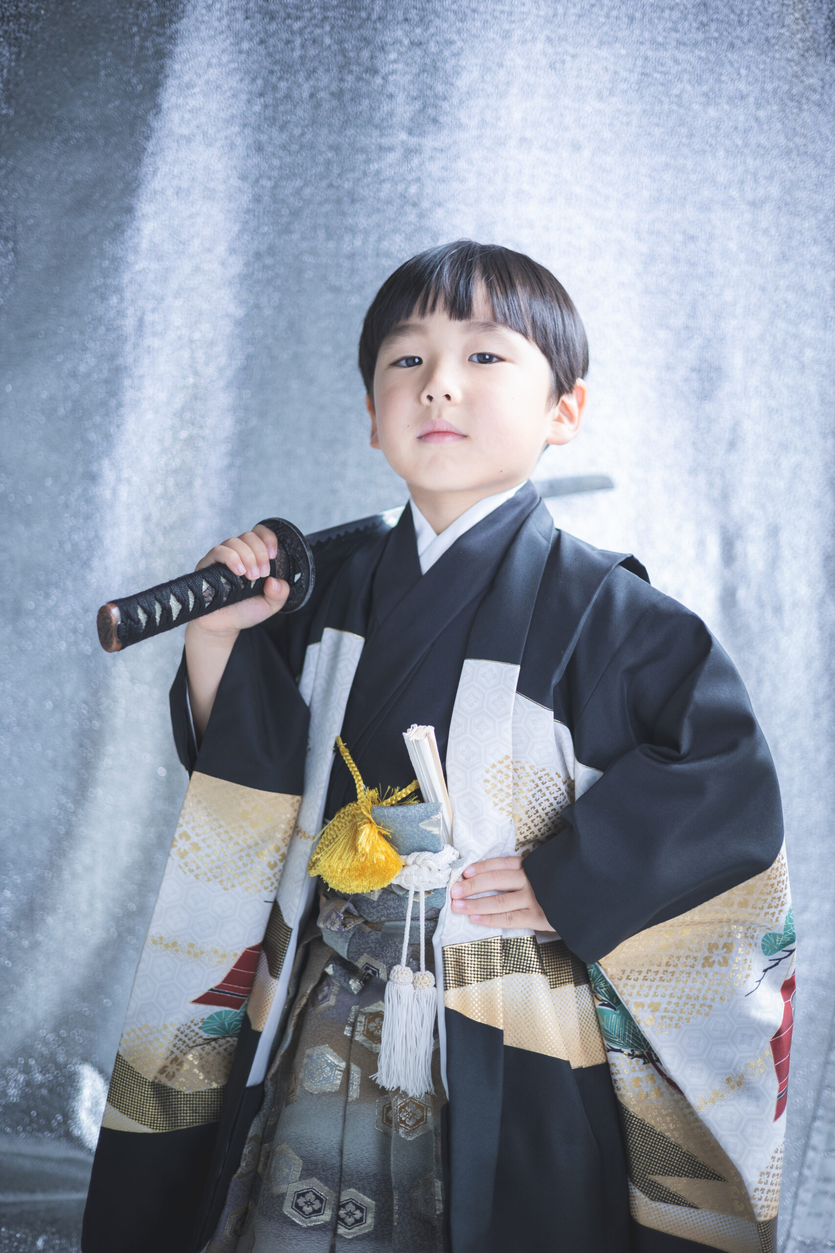 5歳の男の子の七五三,羽織袴で刀を肩にかけて決めポーズ