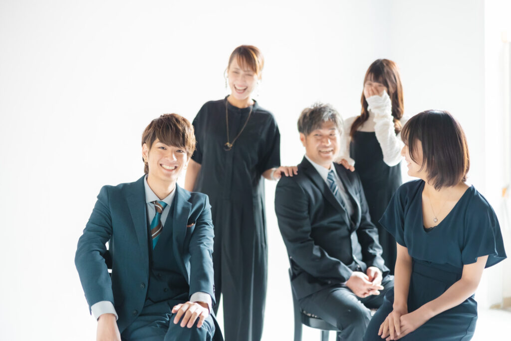成人式を迎える男性の家族記念写真,本人と父親はスーツで母親と2人の妹は黒や紺のワンピース