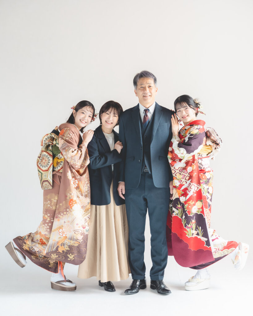 成人式の家族写真を両親と姉と撮影している,両親はスーツで姉は振袖
